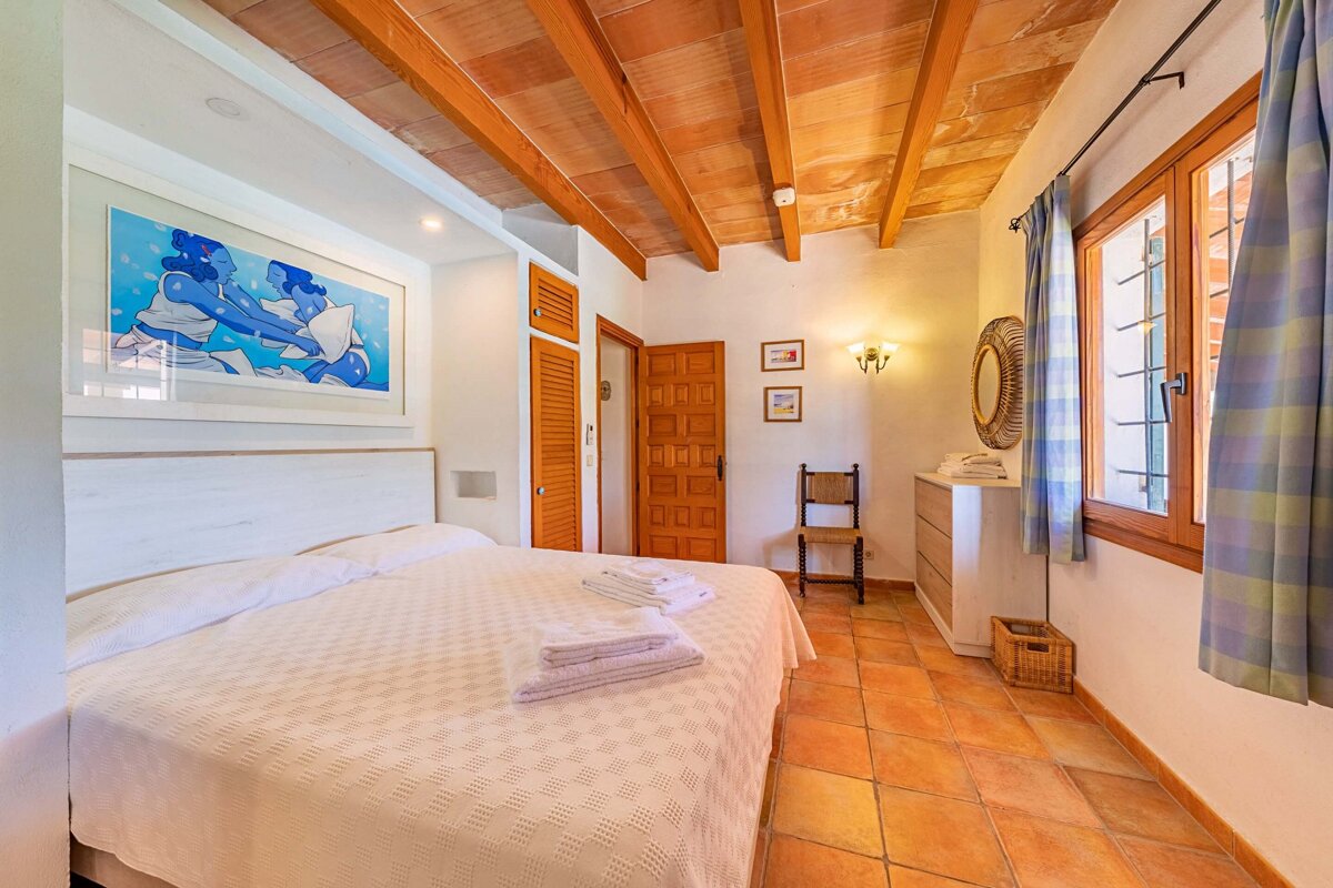 A bedroom with a bed and a picture on the wall