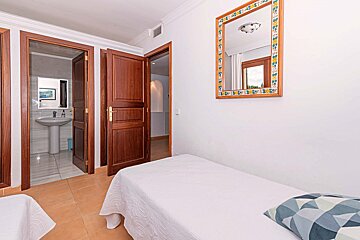 A bedroom with two beds and a mirror on the wall