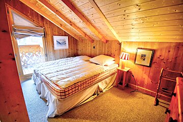 A bedroom with a bed and a picture on the wall