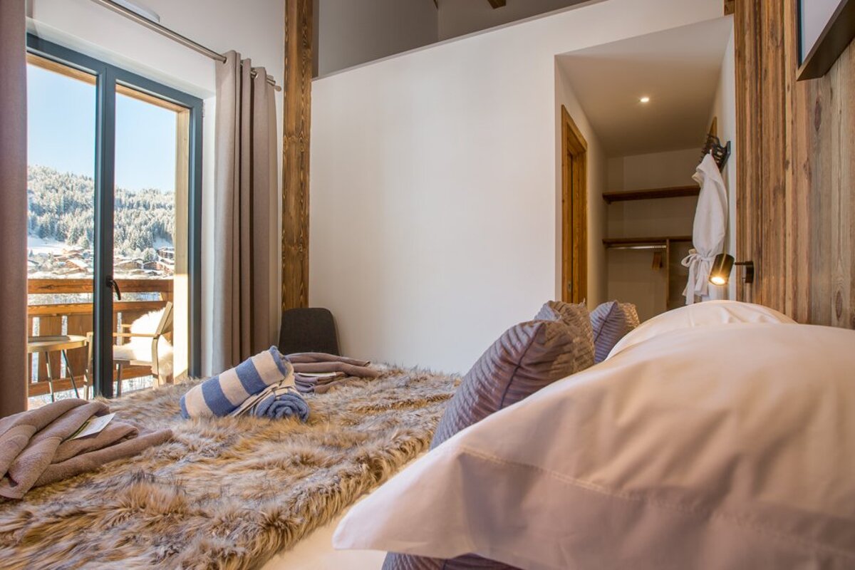 A bedroom with a sliding glass door leading to a balcony