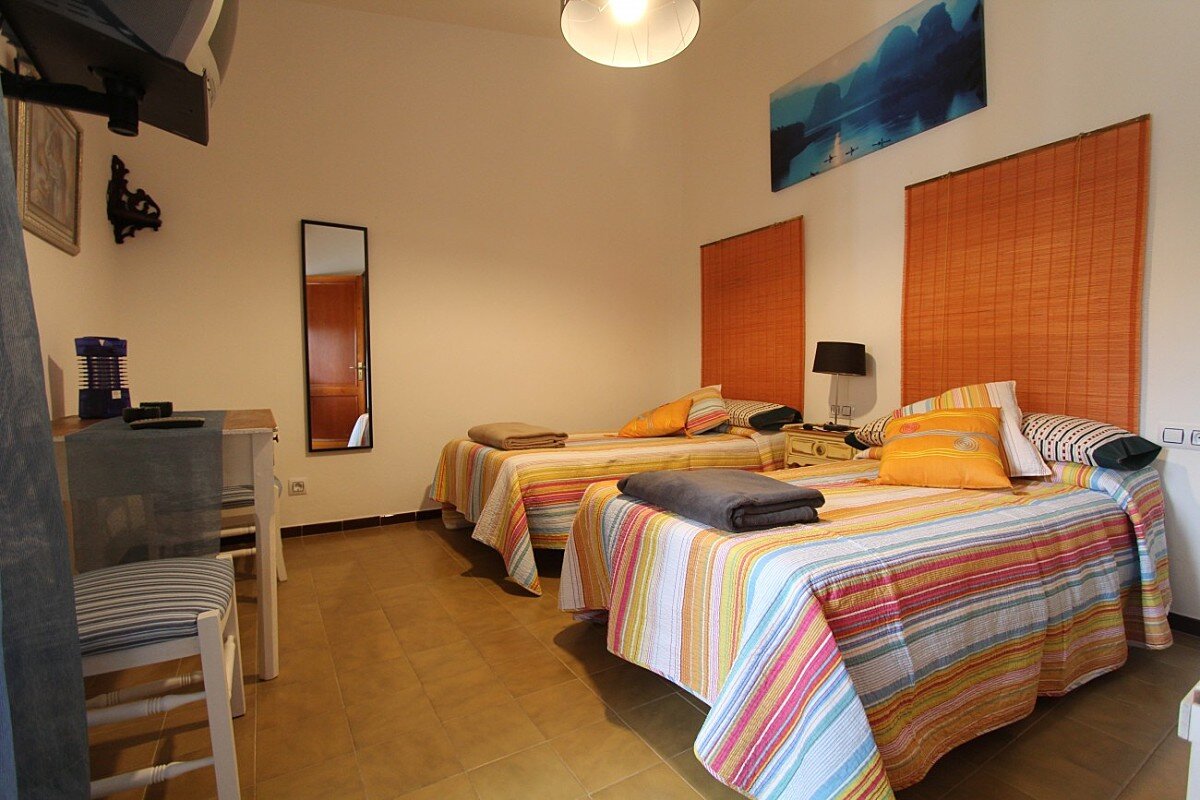 A bedroom with two beds and a mirror on the wall