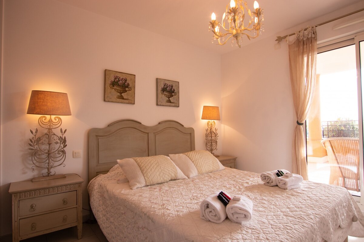 A bedroom with a large bed and two lamps