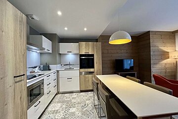 A kitchen with white cabinets and wooden walls
