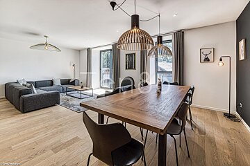 A living room with a large wooden table and chairs