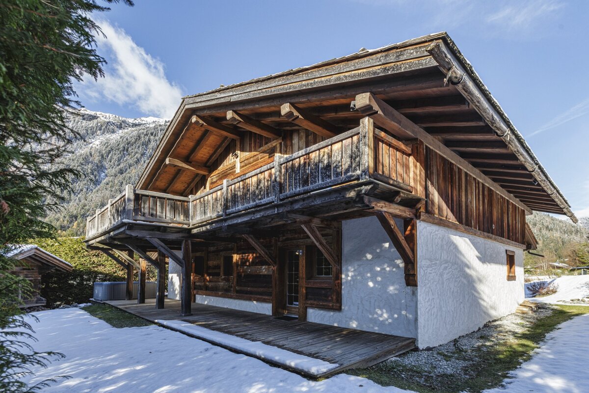 A white building with a wooden roof is surrounded by snow