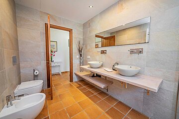 A bathroom with two sinks and a toilet