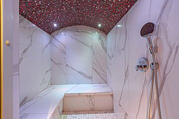 A bathroom with marble tiles and a shower head