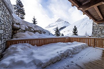 A snowy deck with a mountain in the background