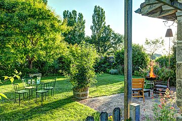 A garden with a table and chairs and a fire pit