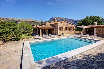 A house with a large swimming pool in front of it