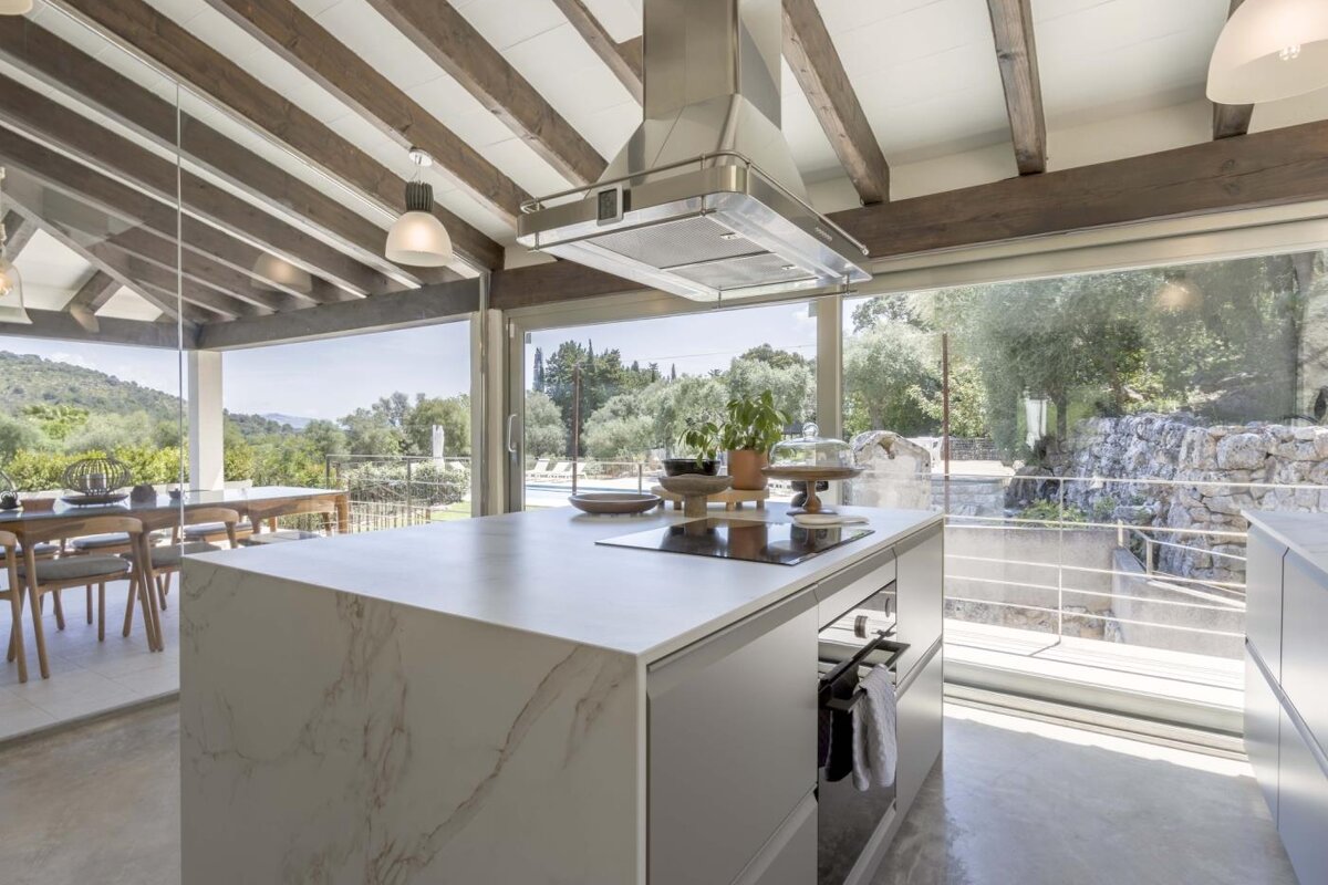 A kitchen with a large island and a stove top oven