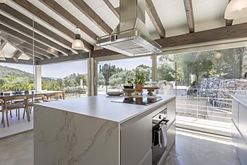 A kitchen with a large island and a stove top oven