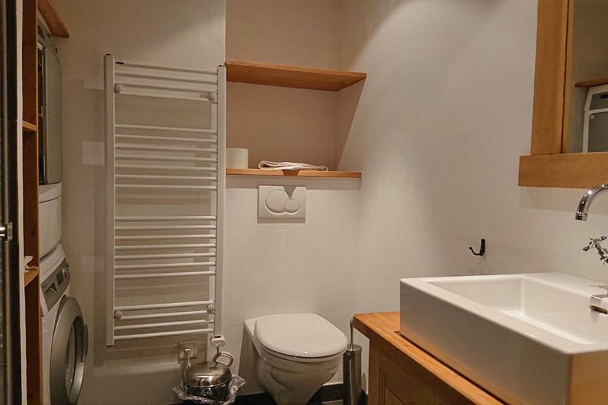 A bathroom with a toilet a sink and a towel rack