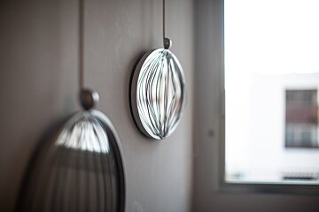 A circular object is hanging from a string on a wall