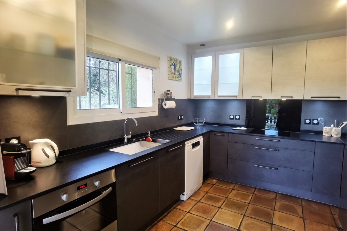 A kitchen with black cabinets and stainless steel appliances