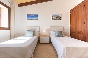 A bedroom with two beds and two pictures on the wall