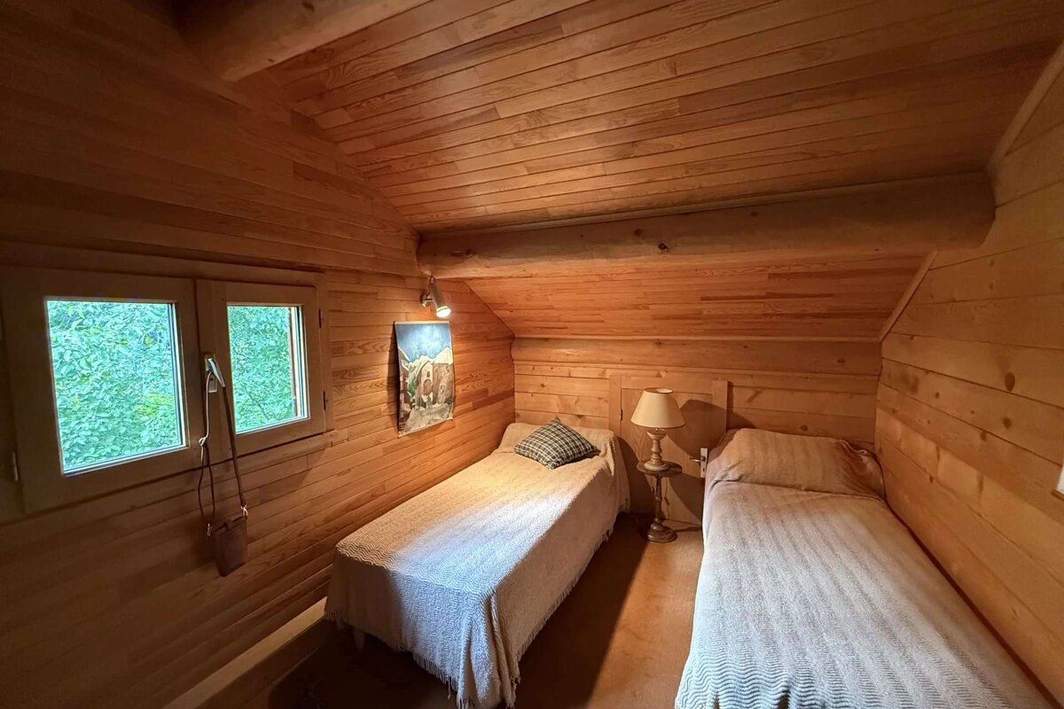 A bedroom with two beds and a painting on the wall