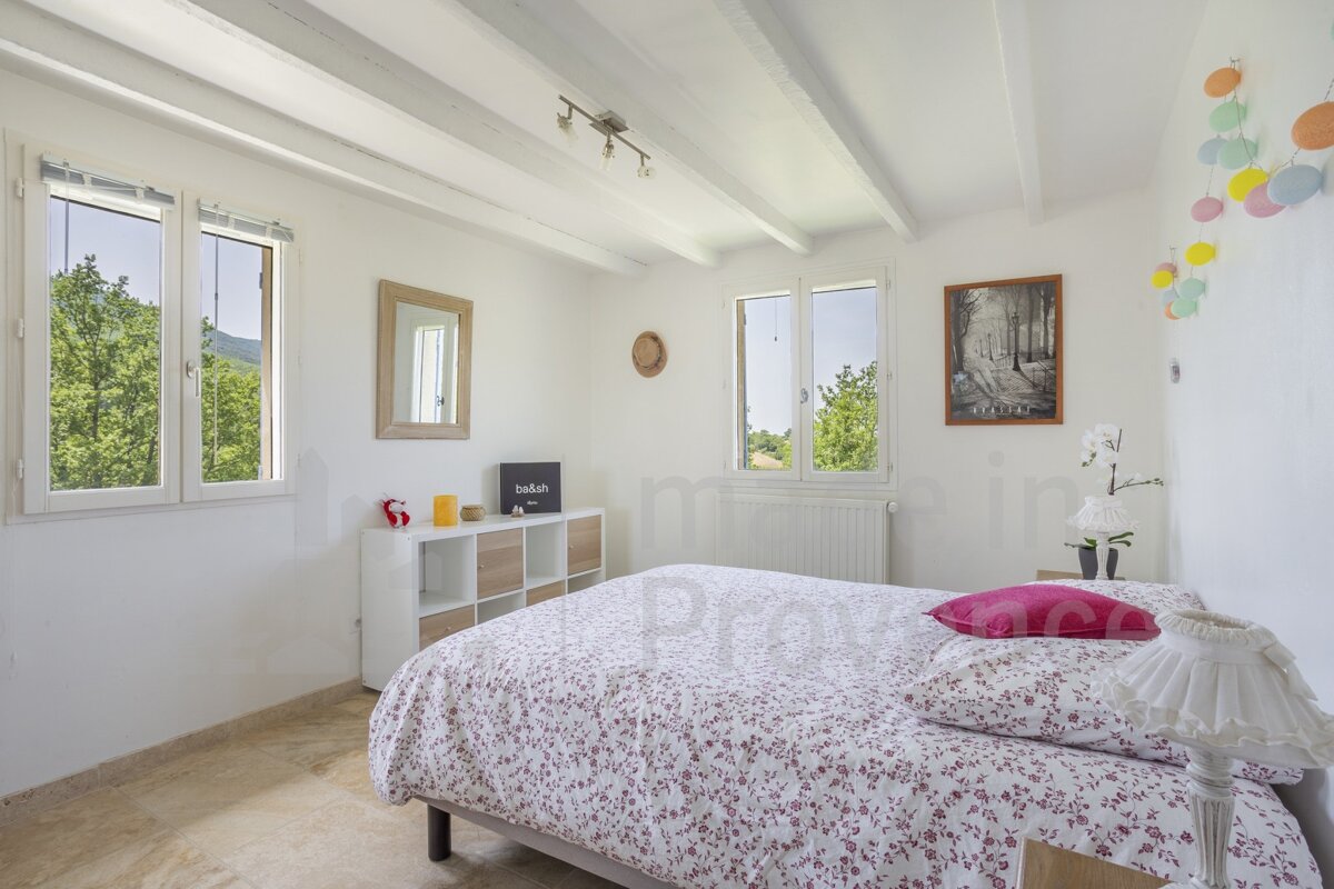 A bedroom with a bed and a picture on the wall that says provence