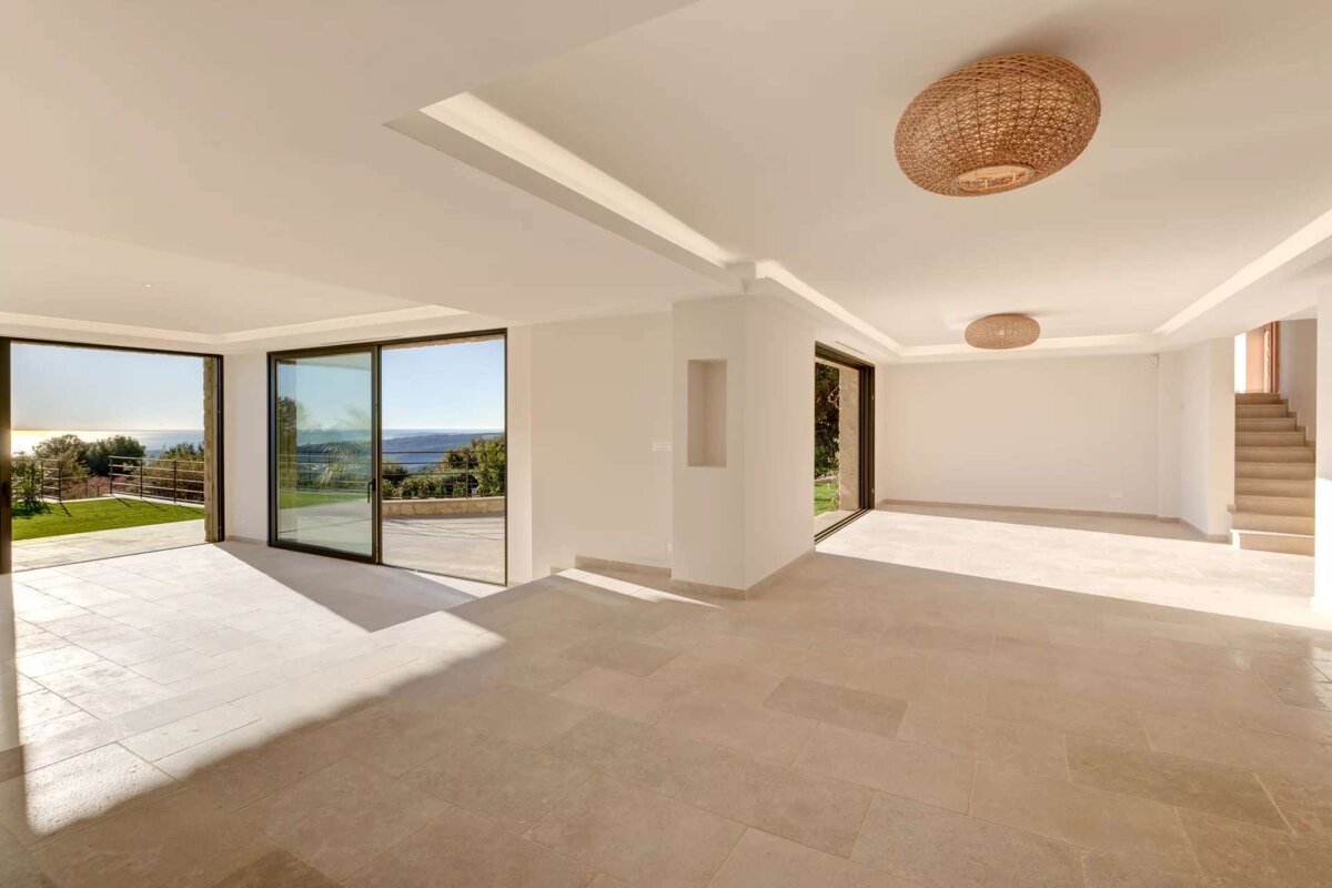 An empty room with a wicker lamp hanging from the ceiling