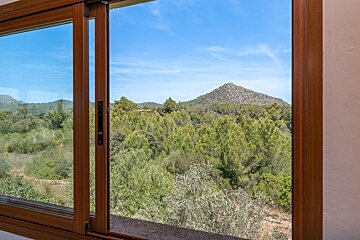 A window with a view of a mountain and trees