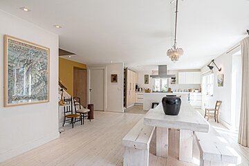 A dining room with a table and benches and a map on the wall