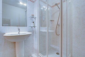 A bathroom with a sink and a walk in shower
