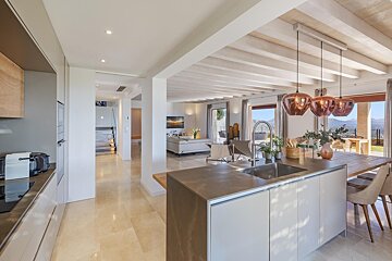 A kitchen with copper pendant lights hanging from the ceiling