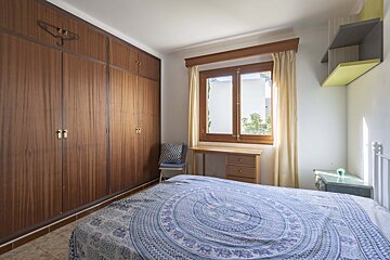 A bedroom with a blue and white blanket on the bed