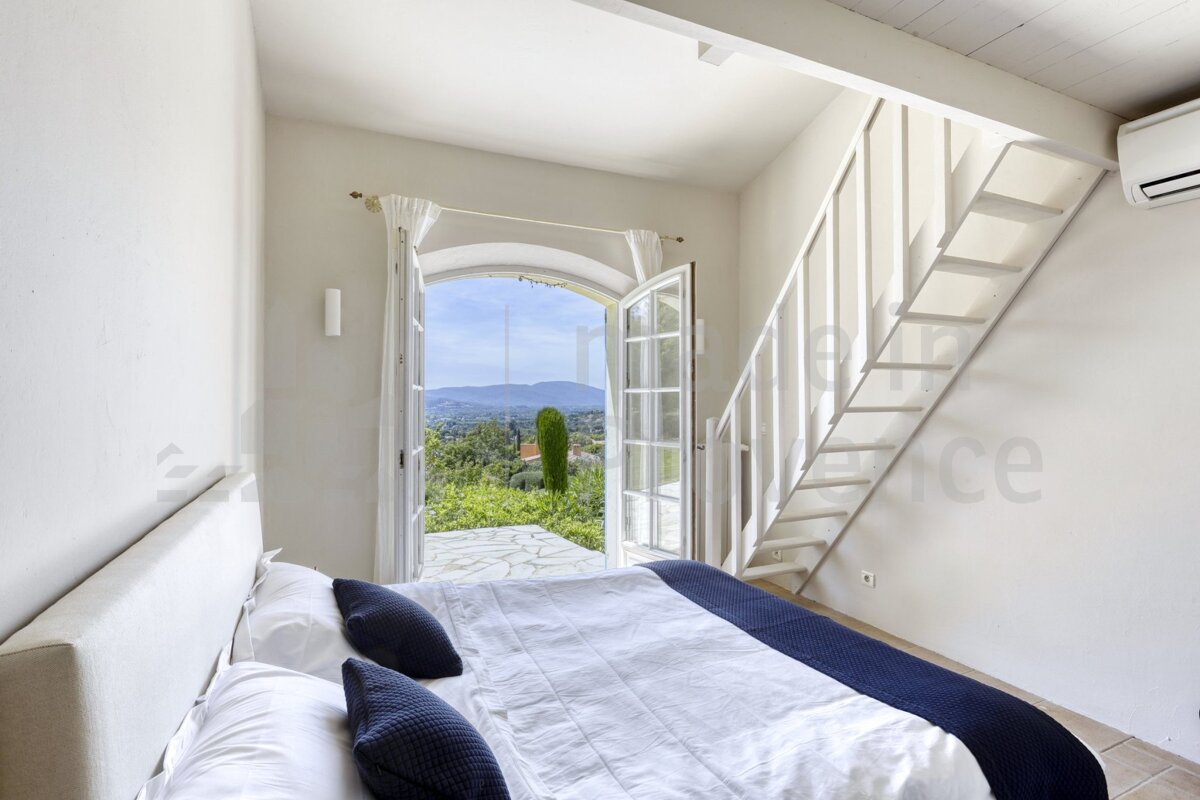 A bedroom with a staircase leading up to the second floor
