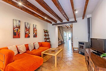 A living room with an orange couch and a flat screen tv