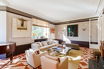 A living room with a piano and a couch that has the word sud on it