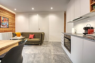A kitchen with a couch and a nespresso machine