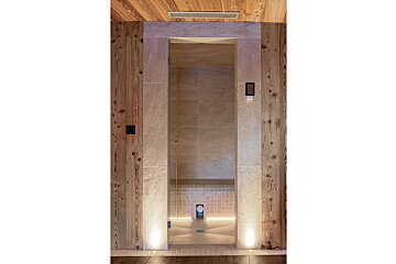 A bathroom with a glass door and wooden walls