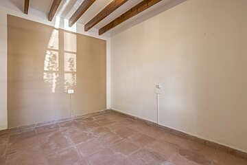An empty room with a light shining through a window