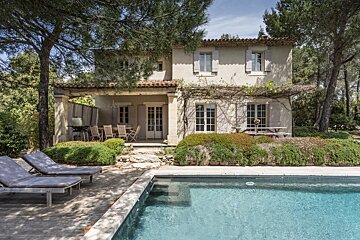 A house with a swimming pool in front of it