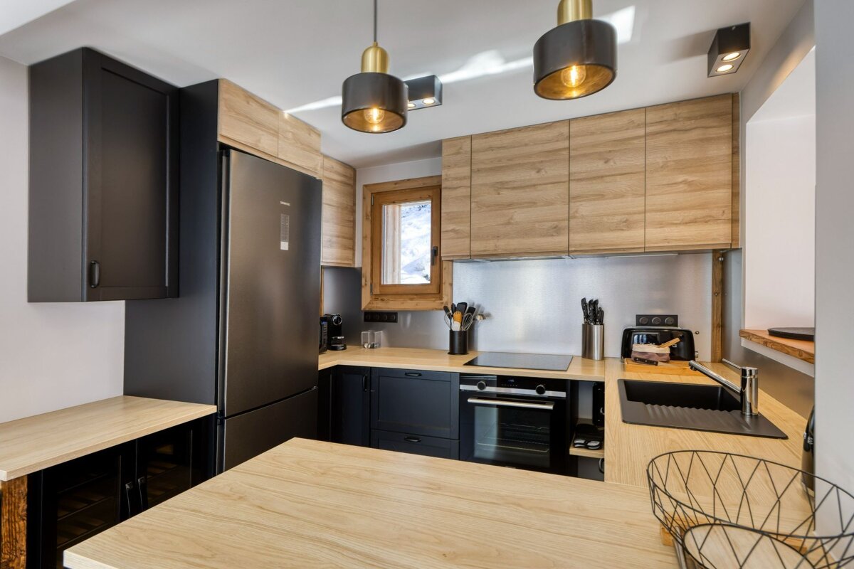A kitchen with black appliances and wooden cabinets