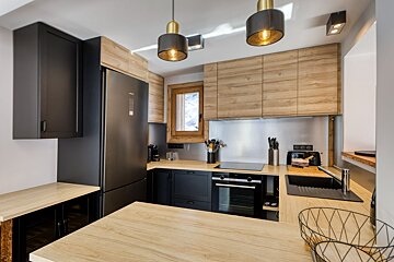 A kitchen with black appliances and wooden cabinets