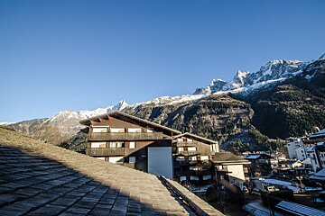 A rooftop view of a ski resort with mountains in the background