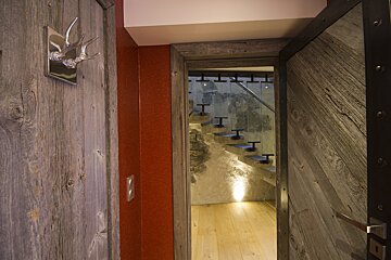 A wooden door with a staircase in the background