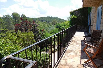 A balcony with a view of trees and mountains