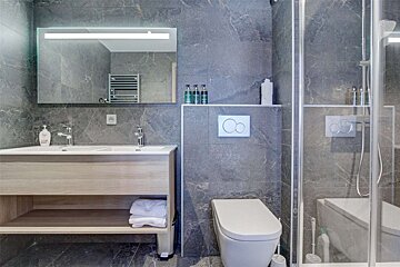 A bathroom with a toilet a sink and a mirror