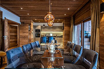 A dining room with a glass table and chairs