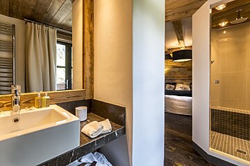 A bathroom with a sink a mirror and a walk in shower