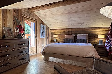 A bedroom with a large bed and a dresser