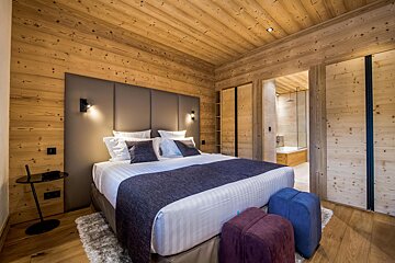A bedroom with a large bed and wooden walls