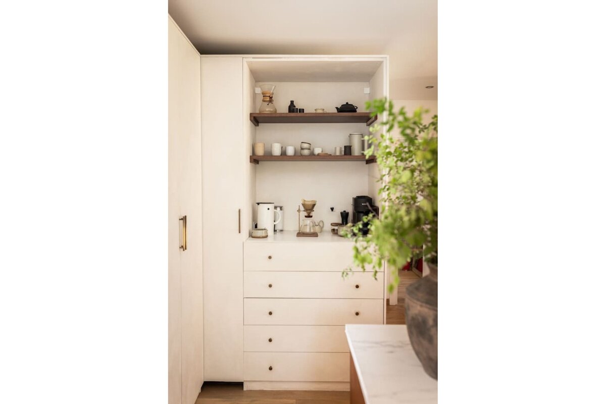 A corner of a room with shelves and drawers