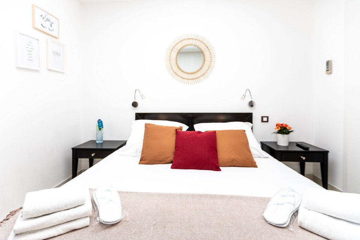 A bedroom with a bed with a red pillow on it