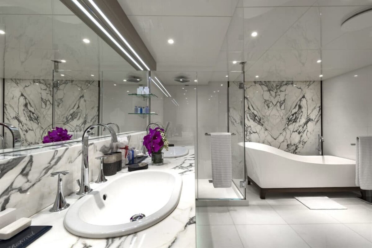 A bathroom with two sinks and a bathtub and a towel that says ' shaving cream ' on it