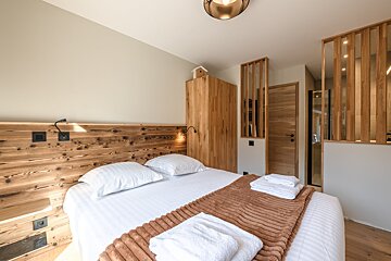 A bedroom with a bed and a sliding glass door
