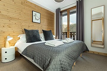 A bedroom with a large bed and a mirror